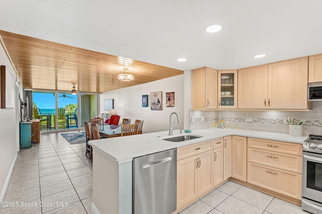kitchen with a sink, light brown cabinetry, stainless steel appliances, light tile patterned floors, and recessed lighting