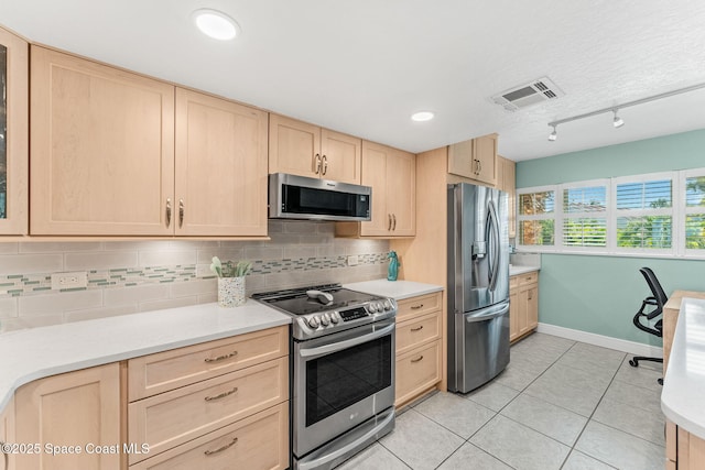 kitchen with appliances with stainless steel finishes, light brown cabinetry, backsplash, light countertops, and recessed lighting