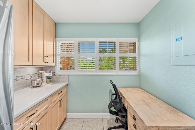 office area featuring electric panel, baseboards, and light tile patterned flooring
