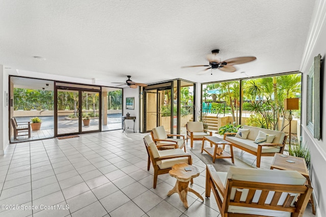 sunroom with a textured ceiling, healthy amount of natural light, tile patterned floors, and a wall of windows