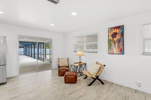 living area with baseboards, recessed lighting, and visible vents