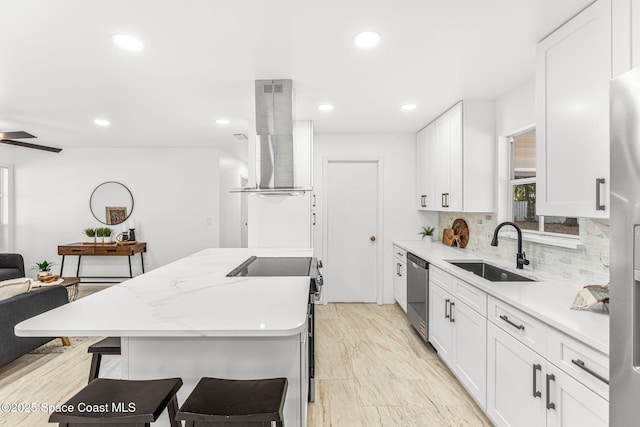 kitchen with a breakfast bar, a sink, dishwasher, electric stove, and island range hood