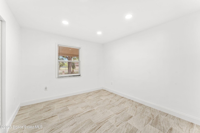 unfurnished room with recessed lighting and baseboards