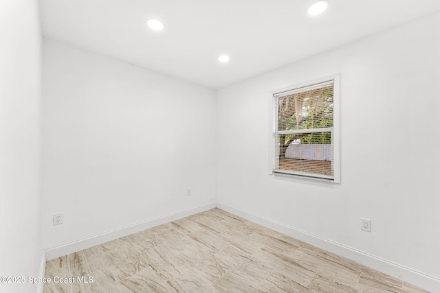 empty room featuring recessed lighting and baseboards