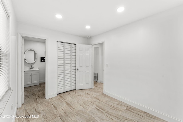 unfurnished bedroom featuring a closet, a sink, visible vents, and recessed lighting