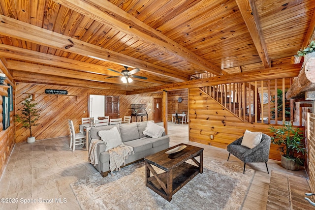 living room featuring a ceiling fan, wood ceiling, beam ceiling, and wooden walls