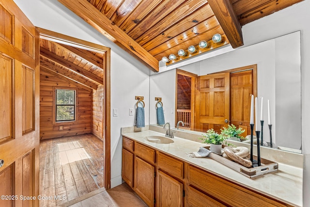 bathroom with log walls, vaulted ceiling with beams, wood-type flooring, and wood ceiling