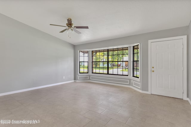 interior space featuring baseboards, a ceiling fan, and lofted ceiling