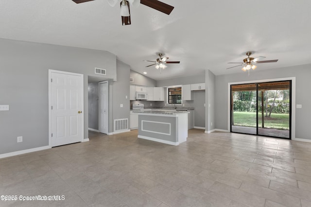 unfurnished living room with vaulted ceiling, baseboards, a ceiling fan, and visible vents