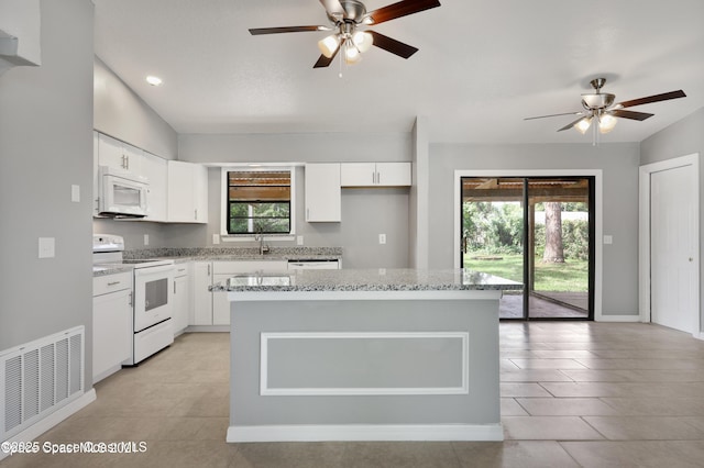 kitchen with visible vents, ceiling fan, white appliances, and light stone countertops