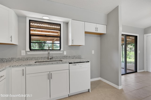kitchen with light stone countertops, baseboards, white dishwasher, white cabinetry, and a sink