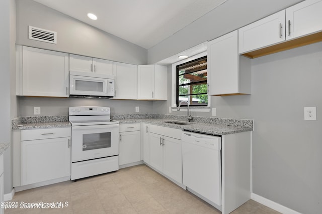 kitchen featuring a sink, white appliances, white cabinetry, lofted ceiling, and visible vents