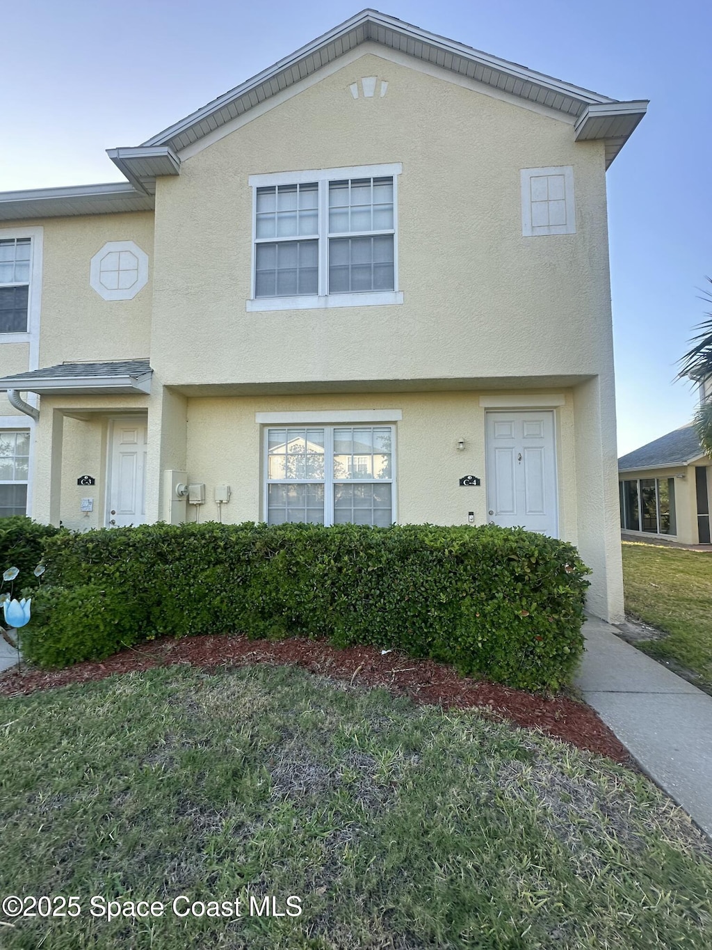 view of property featuring stucco siding and a front lawn