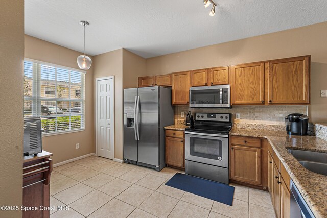 2990 S Fiske Blvd Unit C4, Rockledge, FL 32955 - kitchen with appliances with stainless steel finishes, brown cabinets, tasteful backsplash, and a textured ceiling