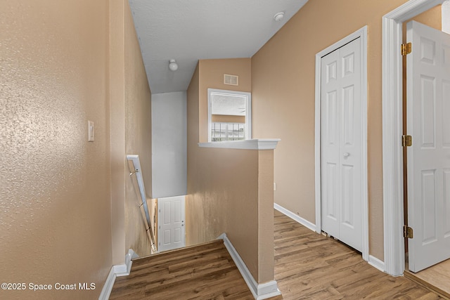 2990 S Fiske Blvd Unit C4, Rockledge, FL 32955 - hallway featuring wood finished floors, an upstairs landing, baseboards, and lofted ceiling
