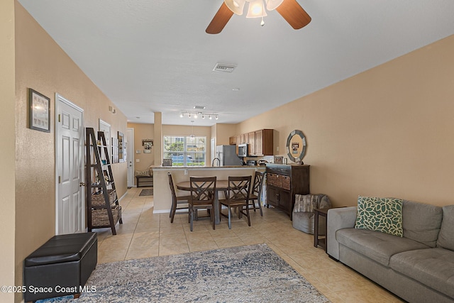 2990 S Fiske Blvd Unit C4, Rockledge, FL 32955 - living room featuring light tile patterned floors, a ceiling fan, and rail lighting