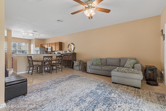 2990 S Fiske Blvd Unit C4, Rockledge, FL 32955 - living room featuring light tile patterned flooring, ceiling fan, baseboards, and track lighting