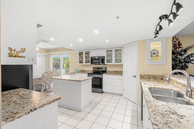 602 Shorewood Dr Unit A201, Cape Canaveral, FL 32920 - kitchen with appliances with stainless steel finishes, a sink, a kitchen island, recessed lighting, and white cabinets