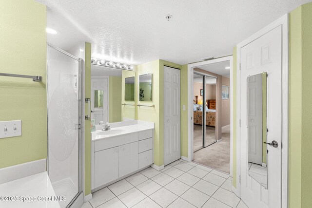 602 Shorewood Dr Unit A201, Cape Canaveral, FL 32920 - bathroom with a stall shower, vanity, baseboards, tile patterned floors, and a textured ceiling