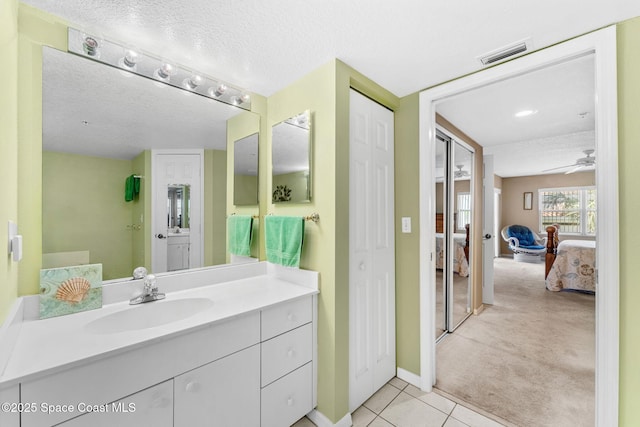 602 Shorewood Dr Unit A201, Cape Canaveral, FL 32920 - ensuite bathroom featuring tile patterned flooring, a ceiling fan, vanity, a textured ceiling, and baseboards