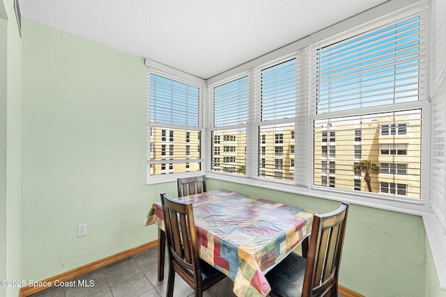 dining area with tile patterned floors, baseboards, and a textured ceiling