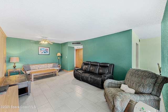 living room featuring a textured ceiling and ceiling fan