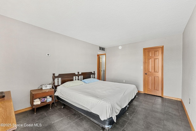 bedroom with baseboards and a textured ceiling