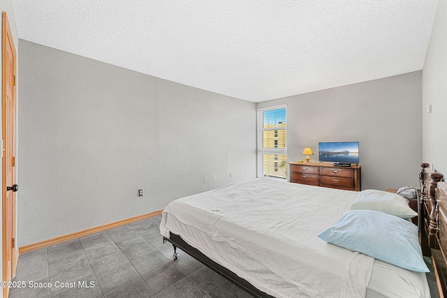 bedroom with baseboards and a textured ceiling