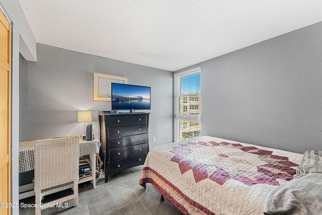 bedroom featuring a textured wall and a textured ceiling