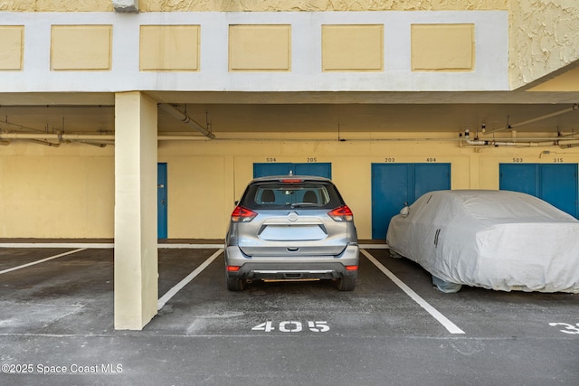 view of vehicle parking featuring a parking garage