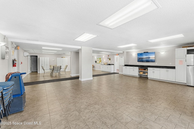 garage with freestanding refrigerator and baseboards
