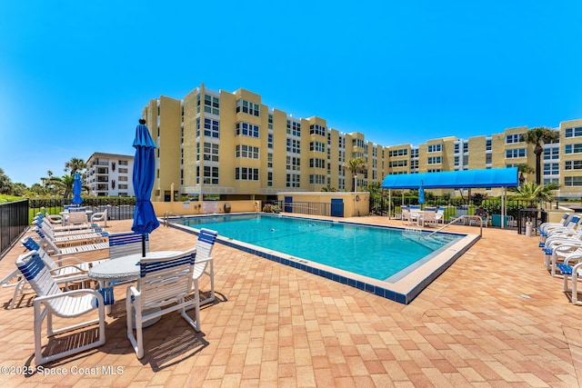 community pool with fence and a patio