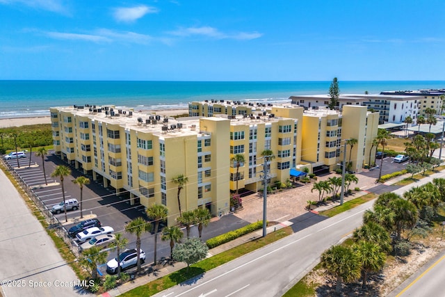 view of apartment building / complex with a water view and uncovered parking