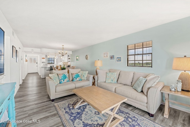 living area featuring an inviting chandelier, plenty of natural light, and light wood-style flooring