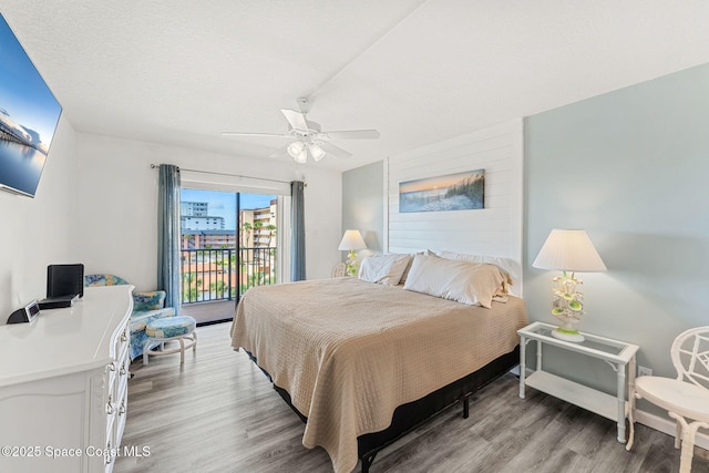 bedroom with light wood-type flooring, a ceiling fan, and access to exterior