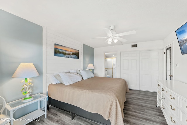 bedroom featuring visible vents, a closet, ceiling fan, dark wood-type flooring, and connected bathroom