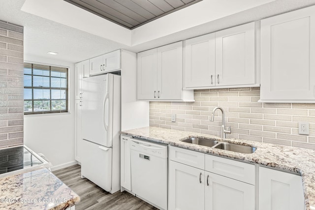 kitchen featuring white appliances, white cabinetry, a sink, and light wood finished floors