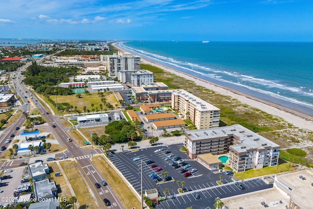 birds eye view of property with a water view and a beach view