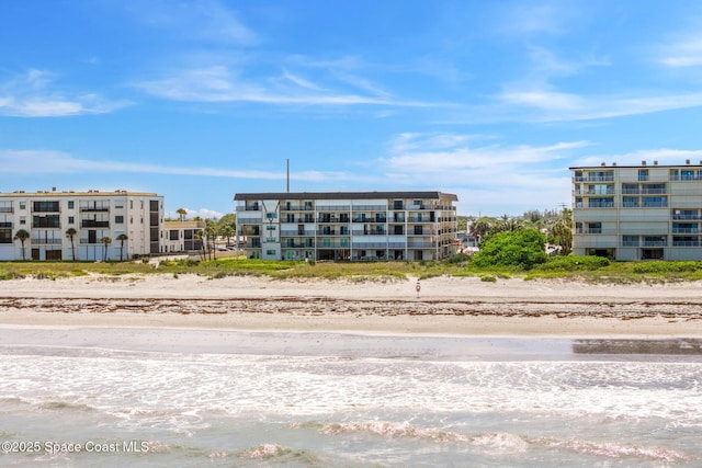 view of building exterior featuring a view of the beach and a water view
