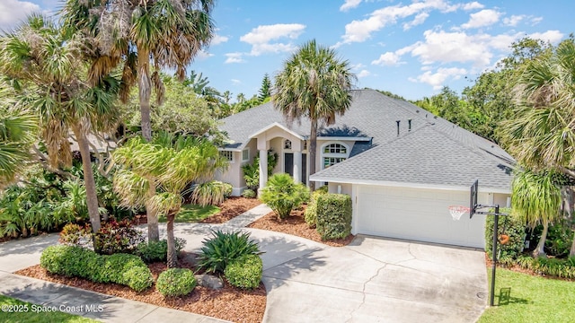 view of front of home featuring an attached garage, a shingled roof, stucco siding, and driveway