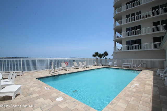 community pool with a patio and fence
