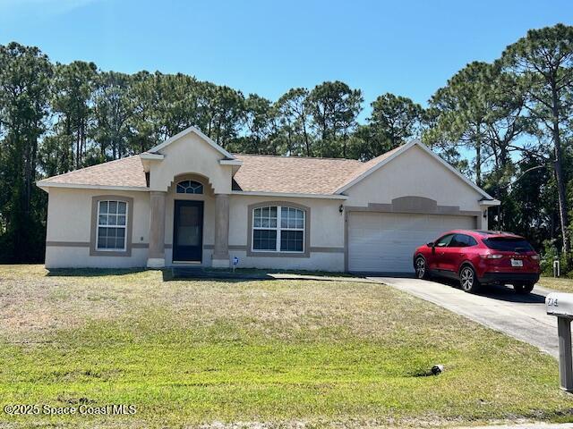 ranch-style home with a garage, stucco siding, concrete driveway, a front lawn, and roof with shingles
