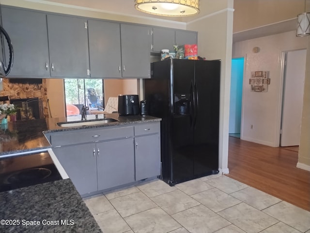 5670 Brandon St, Cocoa, FL 32927 - kitchen with black appliances, a sink, gray cabinets, a fireplace, and baseboards