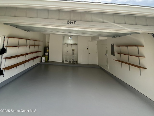garage featuring electric water heater and electric panel