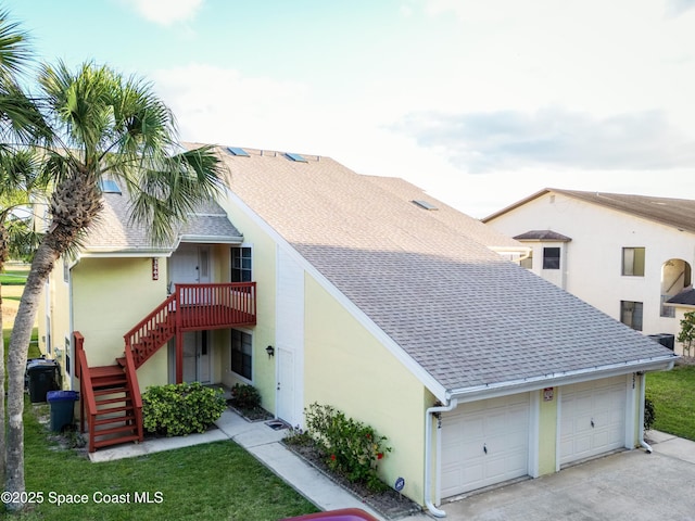 3564 Muirfield Dr Unit 4, Titusville, FL 32780 - view of front of property featuring a shingled roof, stairs, an attached garage, concrete driveway, and stucco siding