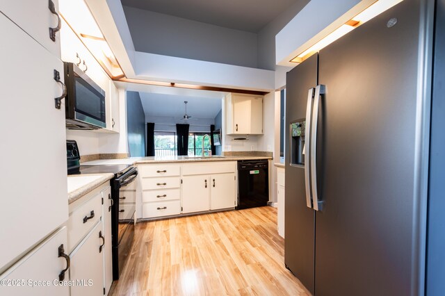 3564 Muirfield Dr Unit 4, Titusville, FL 32780 - kitchen with black appliances, a sink, light wood finished floors, and white cabinetry