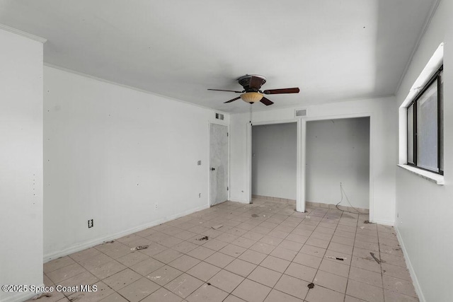 unfurnished bedroom with visible vents, a ceiling fan, multiple closets, and baseboards