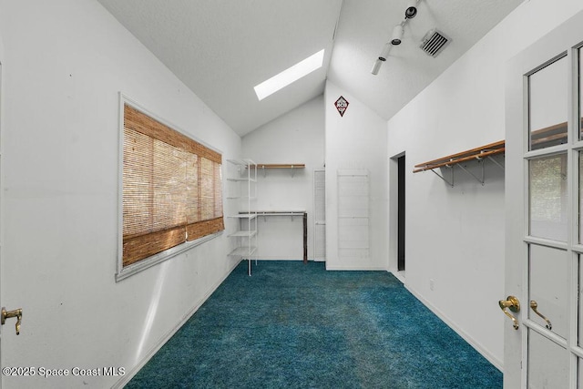 walk in closet with vaulted ceiling with skylight, carpet flooring, and visible vents