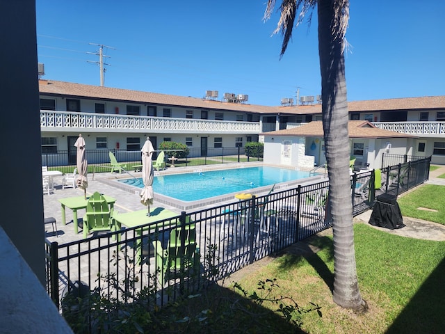 pool with a yard, fence, and a patio area