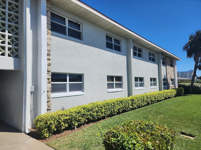 view of home's exterior with a lawn and stucco siding